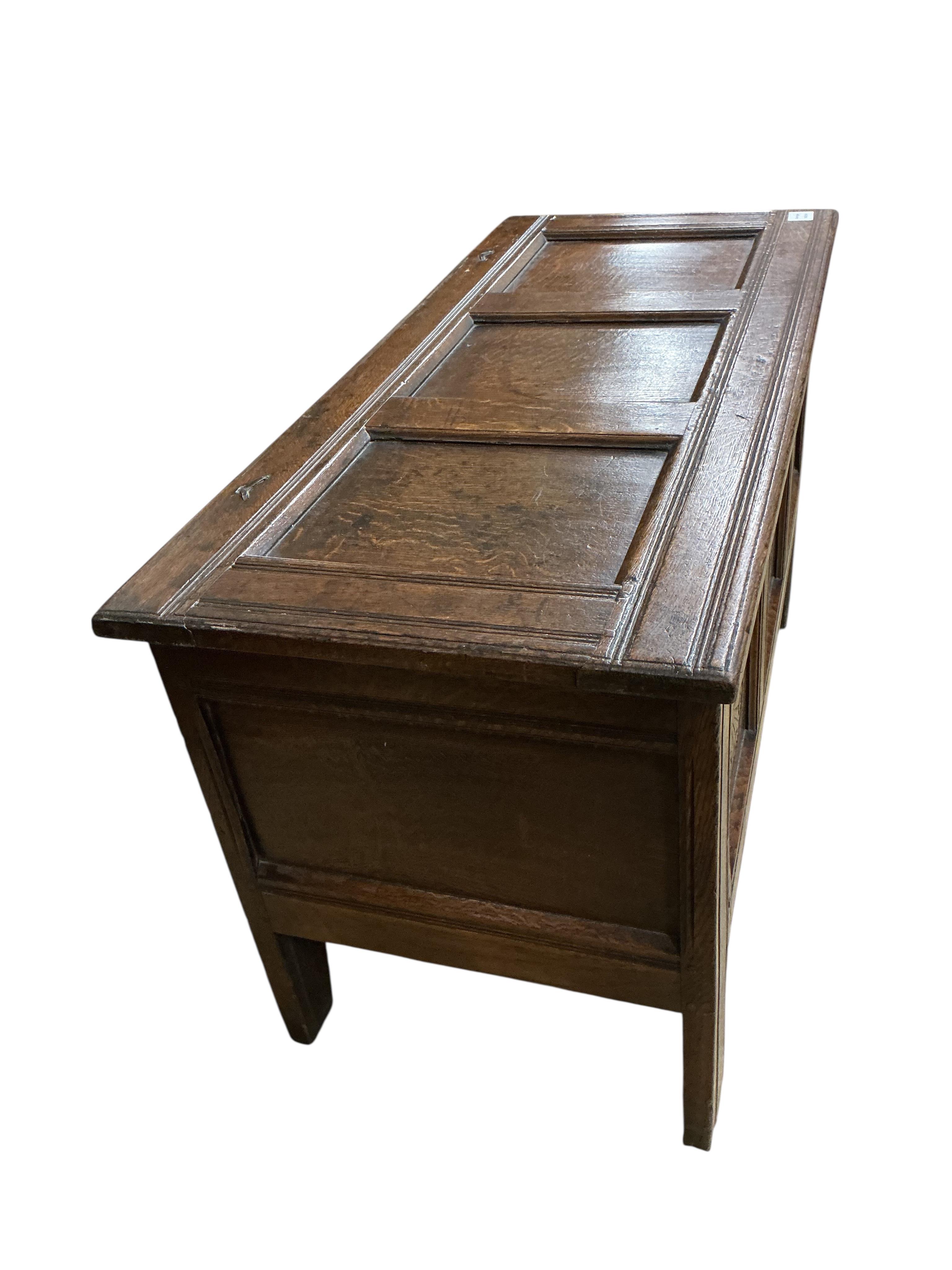 An oak coffer with three panels carved with roundels, width 106cm, depth 47cm, height 61cm